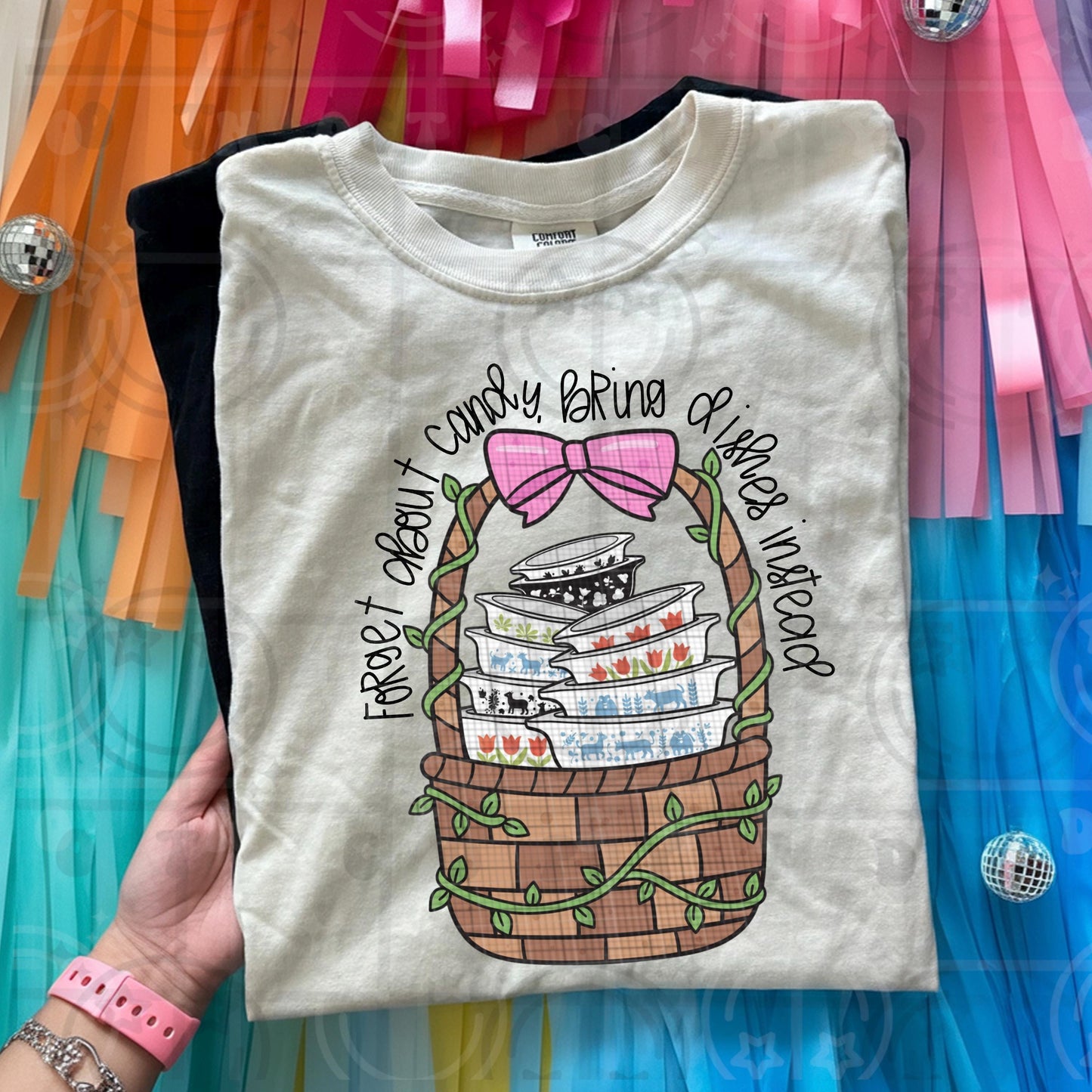 Vintage cottagecore illustration of stacked dishes in a woven basket with greenery and the phrase forget about candy bring dishes instead