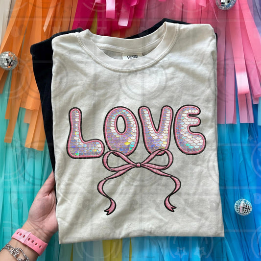 Faux applique love design with printed sequin texture lettering and stitched look pink bow