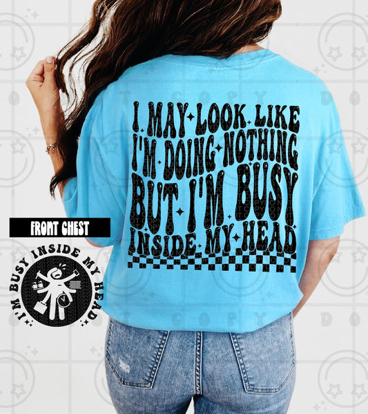 Funny retro wavy quote design reading I May Look Like Im Busy with bold black groovy typography and clean lettering
